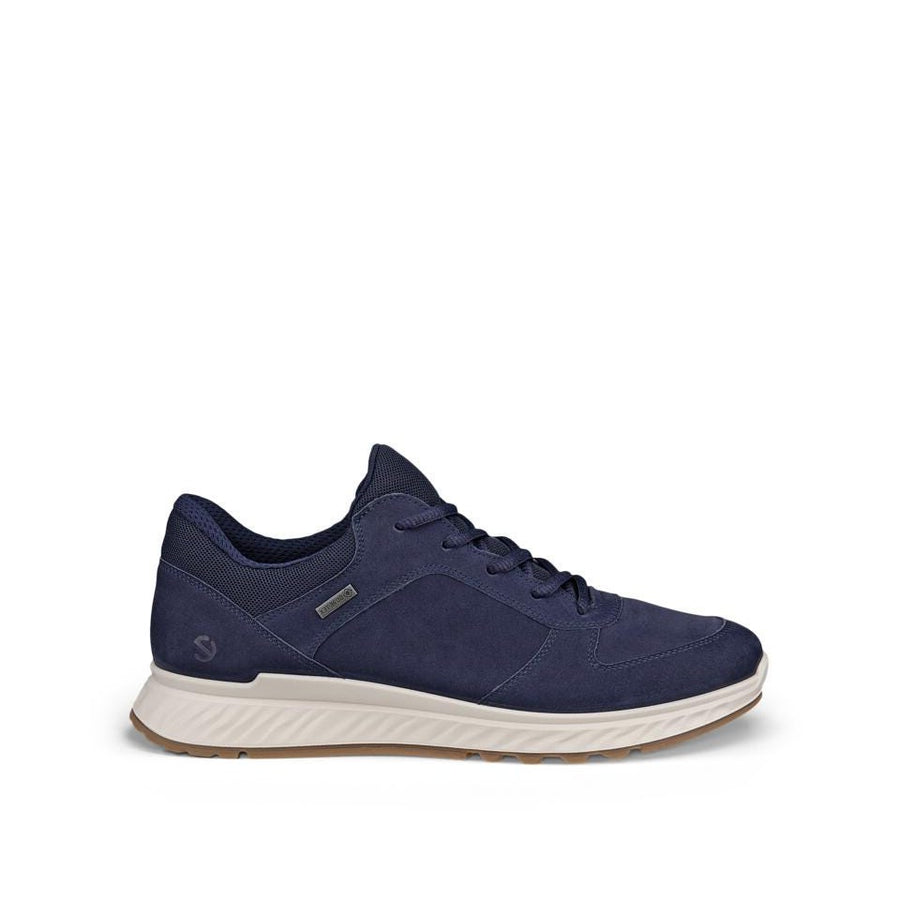 A navy blue suede and mesh athletic sneaker with a thick white midsole and a light brown outsole, shown from a side profile on a white background.